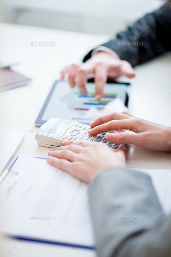 Business colleagues comparing business statistics - Stock Photo - Images