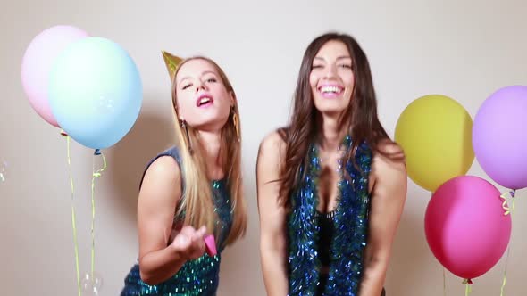 Two attractive girls dancing in photo booth alt