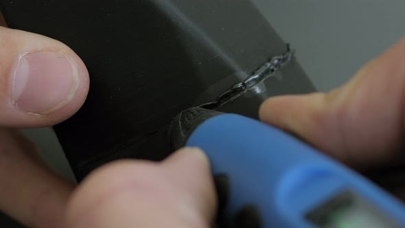 Closeup of Male Engineer Soldering a Plastic Object with a 3D Pen alt