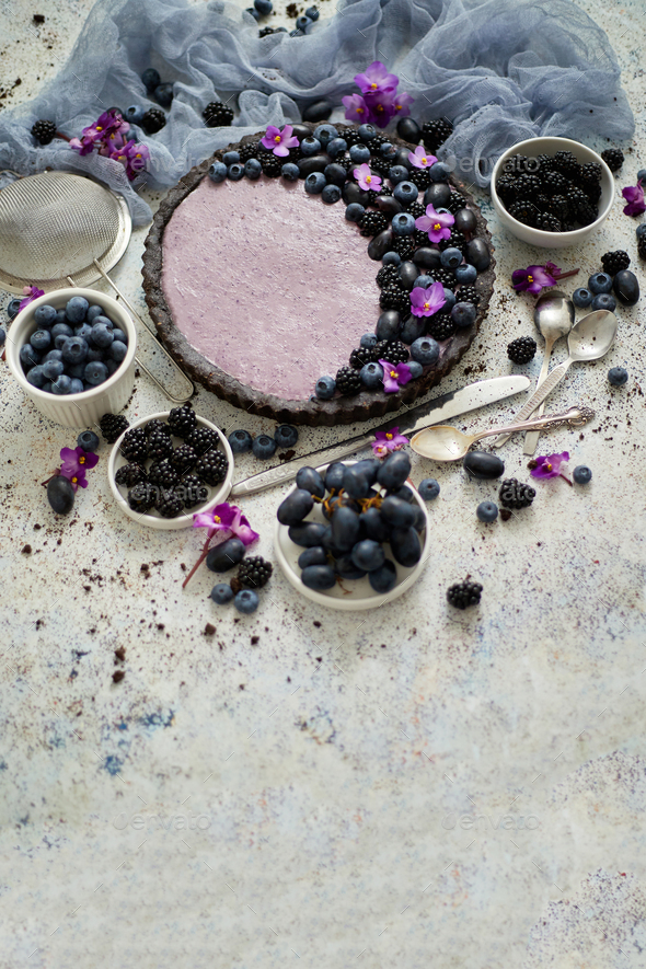 Sweet and tasty tart with fresh blueberries, blackberries and grapes, served on stone background - Stock Photo - Images