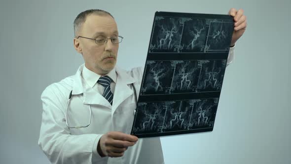 Experienced Cardiologist Checking CT Scan of Blood Vessels, Looking Surprised alt