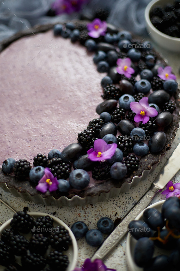 Sweet and tasty tart with fresh blueberries, blackberries and grapes, served on stone background - Stock Photo - Images