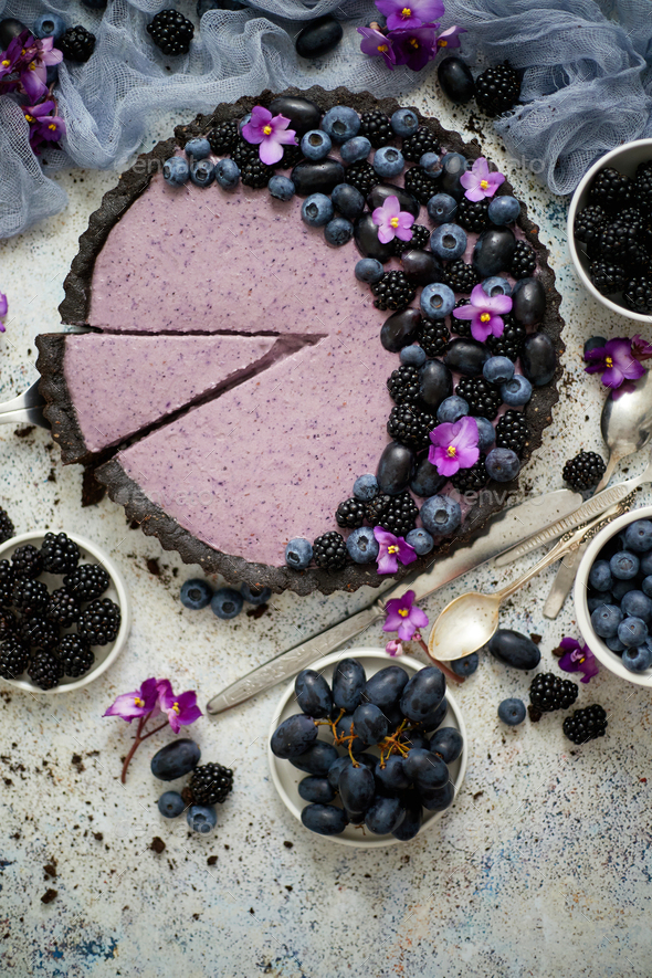 Sweet and tasty tart with fresh blueberries, blackberries and grapes, served on stone background - Stock Photo - Images