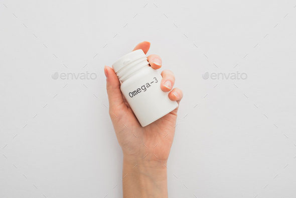 Cropped View of Woman Holding Container With Omega-3 Lettering on White Background