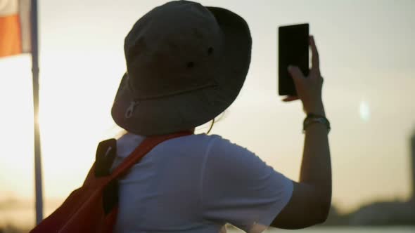 Young Asian women finding networking on mobile beside river location Bangkok Thailand.