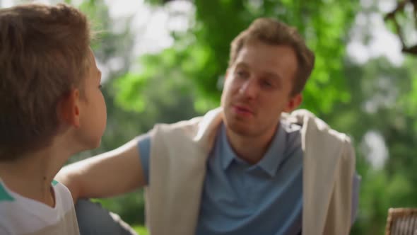 Smiling Father Talking with Son on Nature Close Up alt