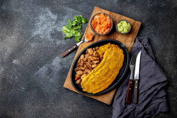 COLOMBIAN CARIBBEAN CENTRAL AMERICAN FOOD. Patacon or toston, fried and flattened whole green - Stock Photo - Images