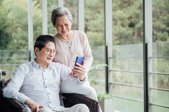 Senior Couple using smartphone on the balcony