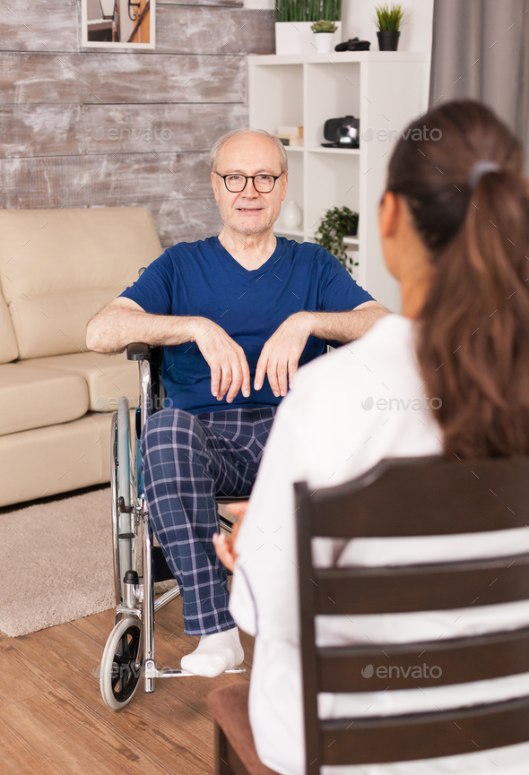 Nurse consulting a man in wheelchair