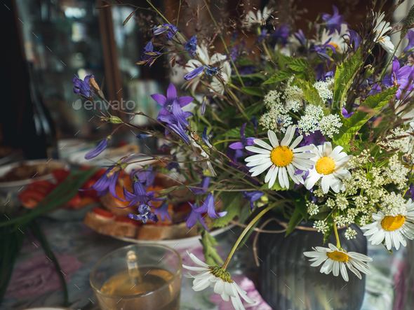 Table setting with wild flowers bouqet.Cottagecore - Stock Photo - Images