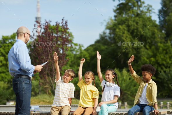 Group of Kids Raising Hands in Outdoor Lesson
