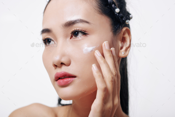 Woman applying rejuvenating cream