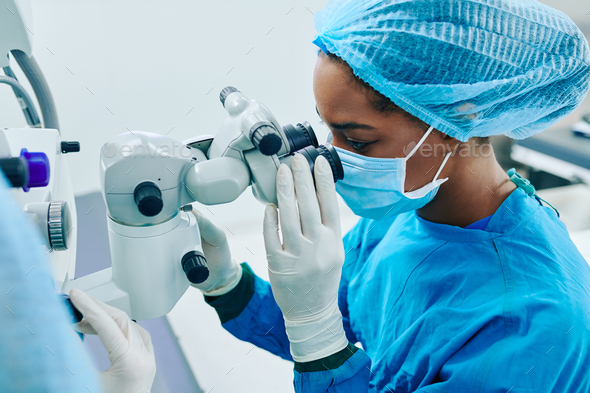 Surgeon looking through electronic miscroscope