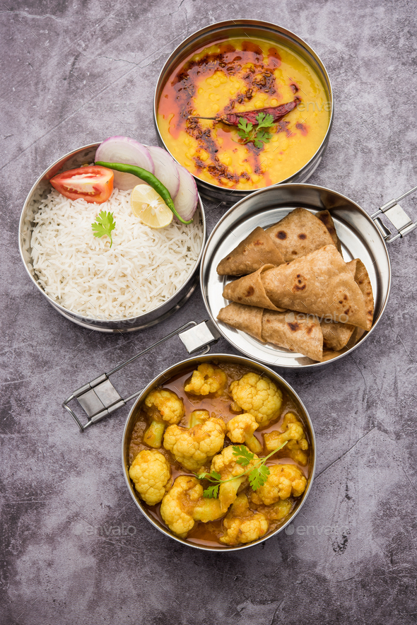 Indian Lunchbox or Tiffin includes Cauliflower Masala, Dal Fry, Rice, Chapati and salad - Stock Photo - Images
