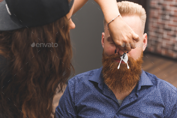 Removing hair from the nose with wax in barbershop male beauty and care concept