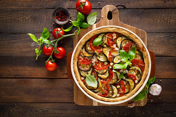 Tart with vegetables. Homemade savory tart with eggplant, zucchini, tomatoes, garlic, mozzarella - Stock Photo - Images