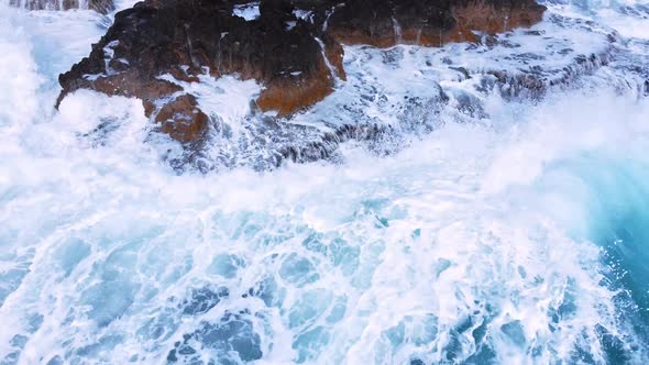 Aerial View of Waves Break on Rocks in a Blue Ocean Sea Waves on Beautiful Beach Bird's Eye View of alt