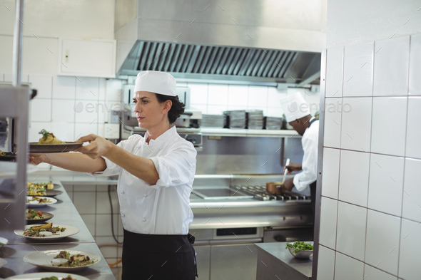 Female chef keeping appetizer plate ready on the order station