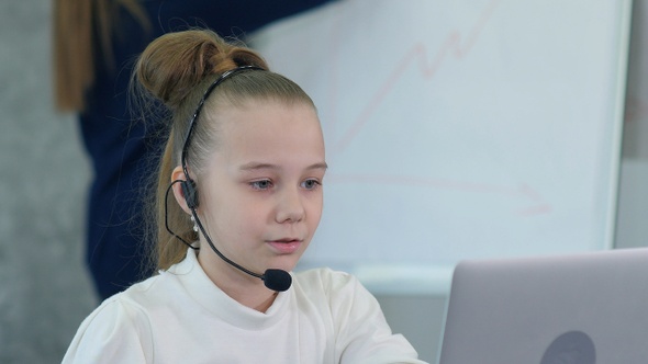 Little business girl talking on the headset in an office