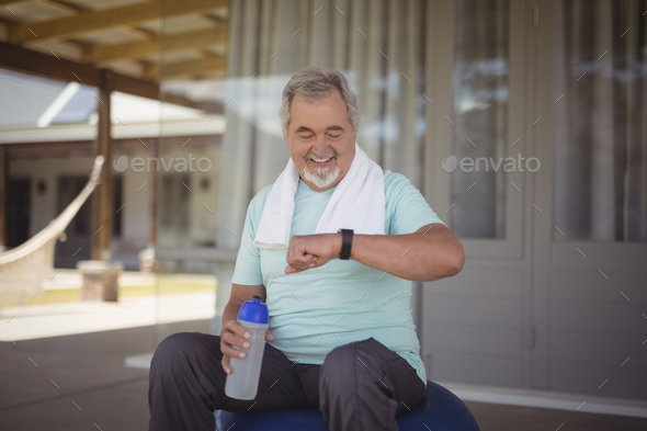 Senior man checking time on wristwatch after work out