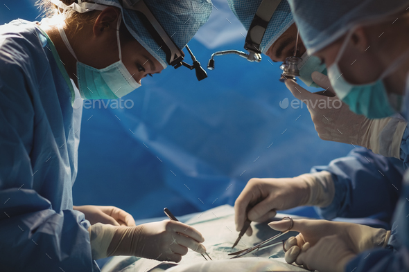 Surgeons performing operation in operation room - Stock Photo - Images