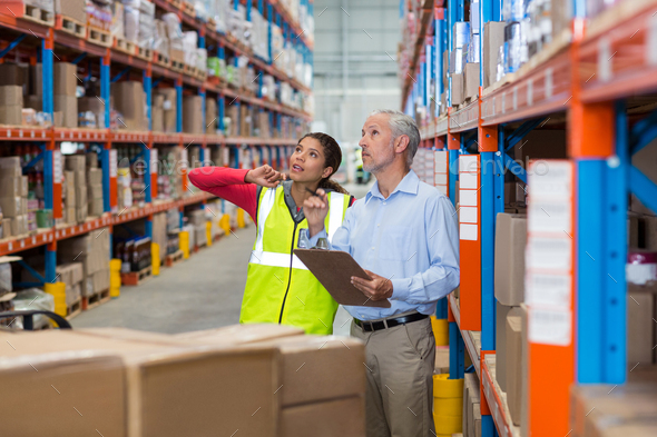 Warehouse manager and female worker interacting while checking inventory - Stock Photo - Images