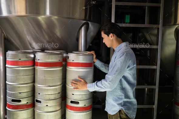 Manager checking beer keg in warehouse