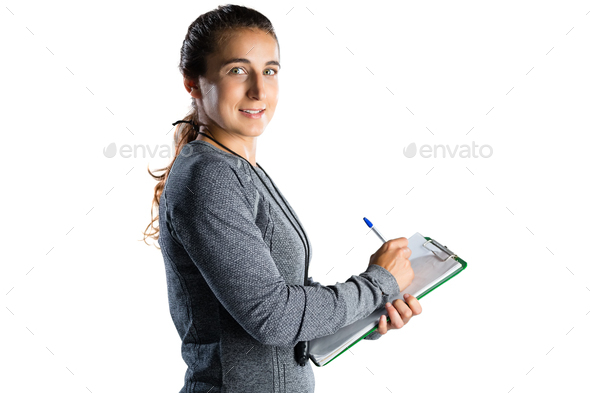 Portrait of rugby coach writing on clipboard