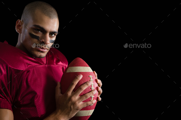 Football Player Holding Football With Both Hands Stock Photo