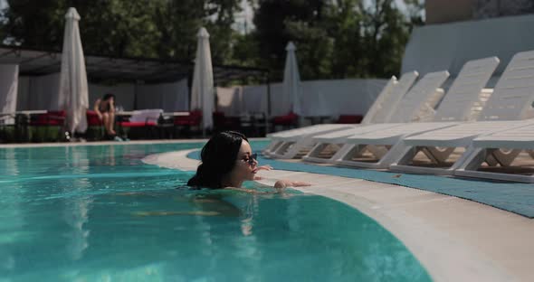 Sexy Naughty Woman in Bikini Resting in the Pool