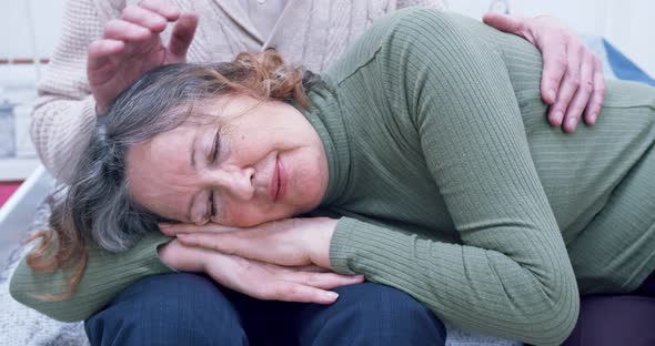 Portrait of an Elderly Woman Lying on Her Loving Husband's Lap in a Cozy House alt