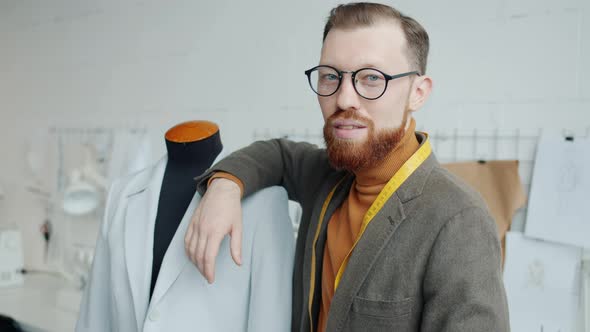 Talented Young Tailor Standing in Studio Next to Dummy Smiling Looking at Camera alt