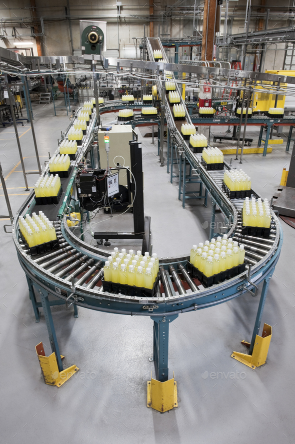 Converyor belt full of lemon flavored bottled water in a bottling plant.