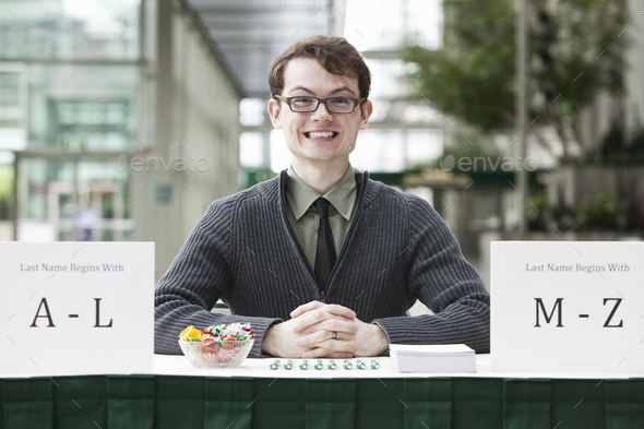 Young hip business man at a registration desk.