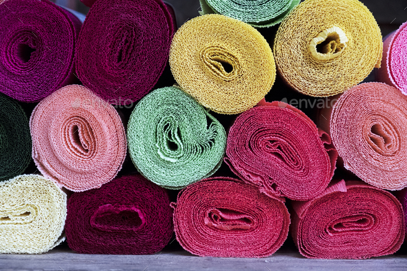 Close up of a selection of rolls of fabric in various colours.