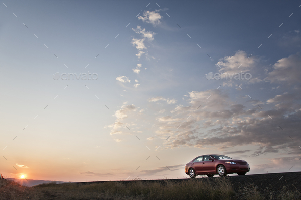 Low angle view looking up at a convertible sports car on the road at sunset. - Stock Photo - Images