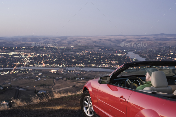 A man parked in a convertible sports car looking over the Clearwater River, Lewiston, Idaho, USA. - Stock Photo - Images