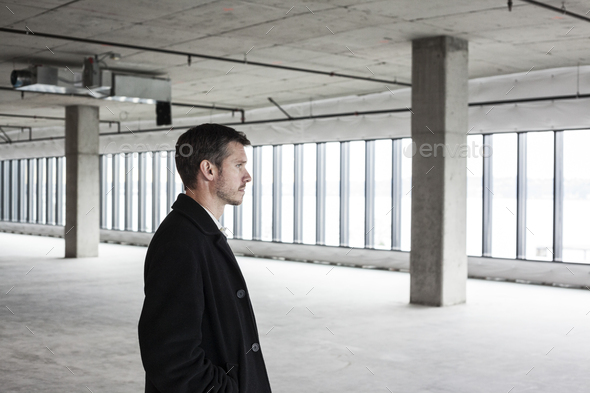 A man standing in an empty office space planning ahead, space to expand.