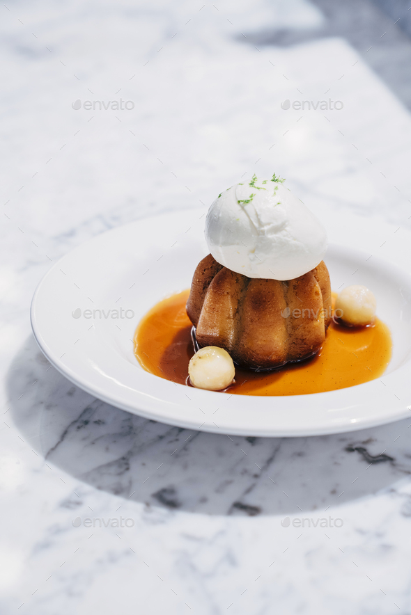 Rum Baba cake with banana caramel and lime ice cream Stock Photo by