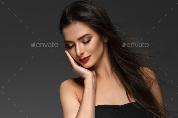 Beautiful woman with long brunette smooth beauty hair over dark backgroun. Female model - Stock Photo - Images