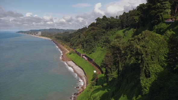 Mountains Covered Trees, Cliff To Beach Sea with Railway Tracks Tunnel, Train Moving, Garden on Hill alt