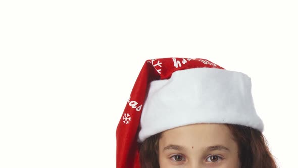 The Head of a Girl Dressed in a Santa Claus Hat Is Shown Close Up