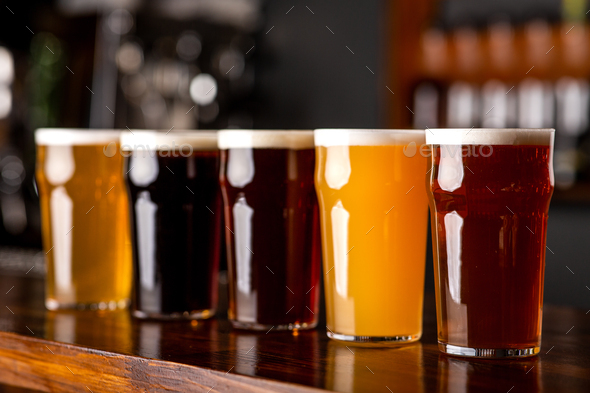 Dark, light, barley, lager and ale in glasses on bar counter