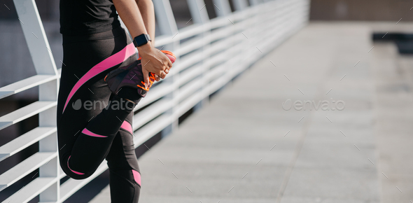 Outdoor and workout lifestyle concept. Girl in sportswear with fitness tracker does warm up for legs