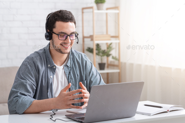 Conversation with client and video call. Guy with glasses and headset gesticulating with hands and
