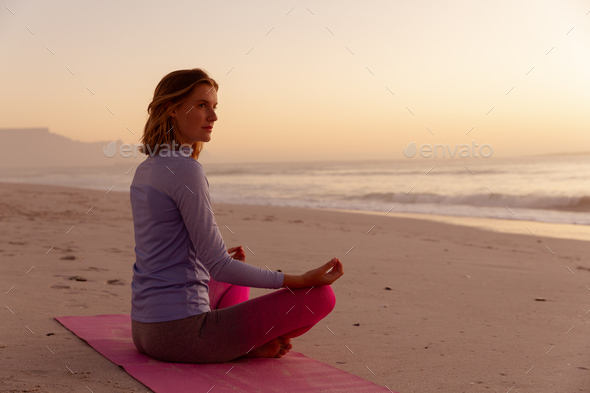 Woman performing yoga on the beach during sunset Stock Photo by ...