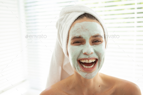 Portrait of woman with face pack smiling