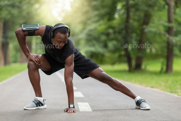 Flexible black man training at public park