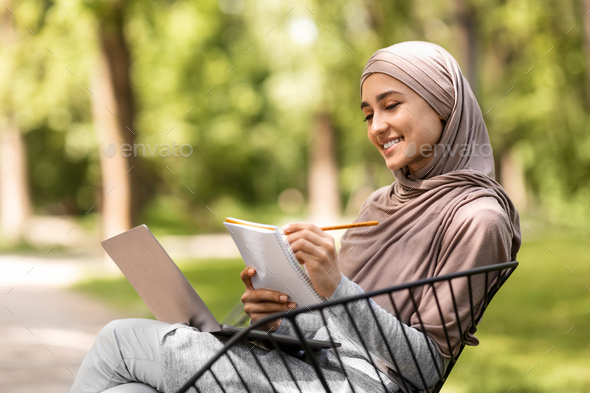 Intelligent arab girl studying at public park