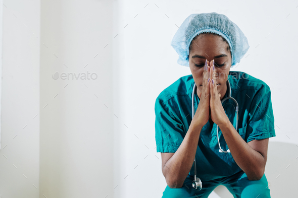 Nurse praying for sick and suffering people